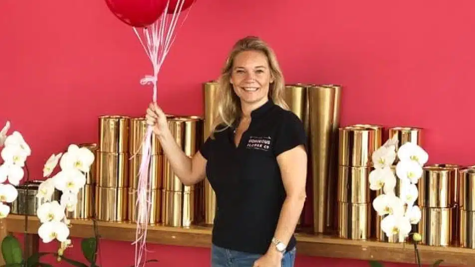 The gorgeous flower company owner Sam Middleton holding balloons in the store and smiling
